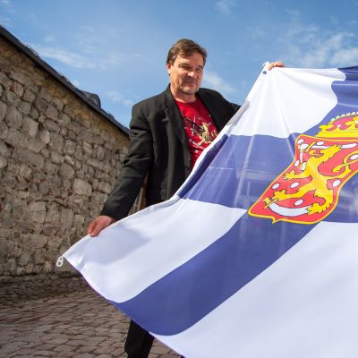 Kimmo Kiljunen pitelee ensimmäistä Suomen lippua