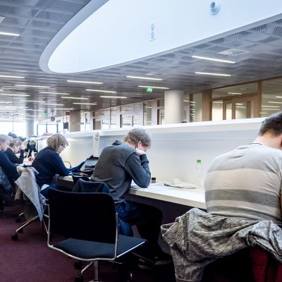 Opiskelijat lukevat kirjastossa