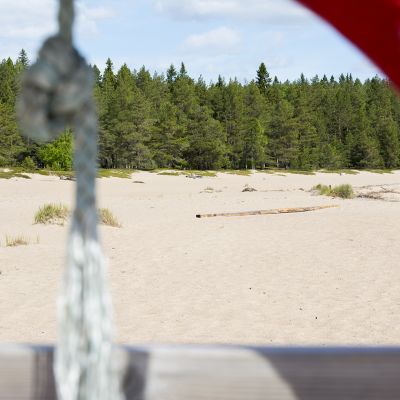 Kuvan etualalla on pelastusrengas ja takana hiekkaranta.
