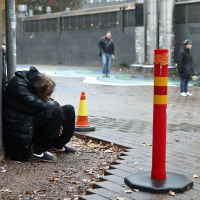 Mies nukkuu seinänvierustalla Helsingissä.