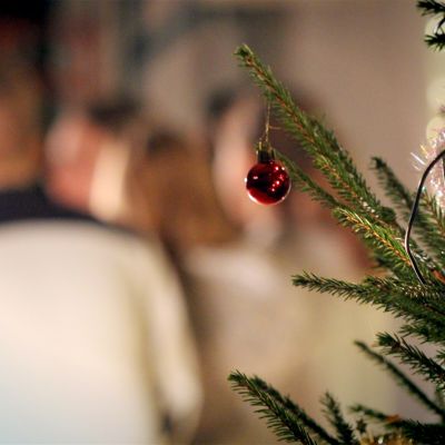 Joulukuusi etualalla, takana koulun oppilaita.