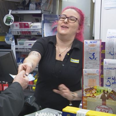 R-kioskin myyjä ojentaa toimittaja Matti Toivoselle 20 euron setelin, jonka Matti on nostanut tililtään oston yhteydessä.