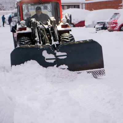 Yrittäjä Teemu Räsänen auraa lunta Kuopion Männistössä.