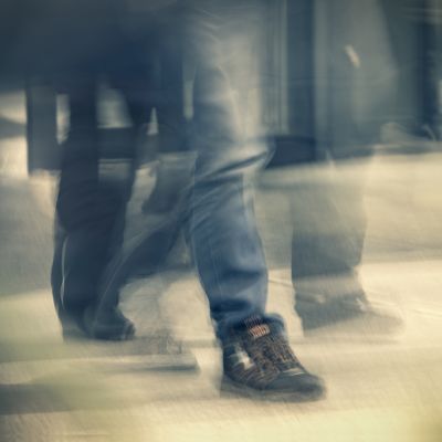 Nuori ihminen kävelee farkut ja kengät jalassaan.