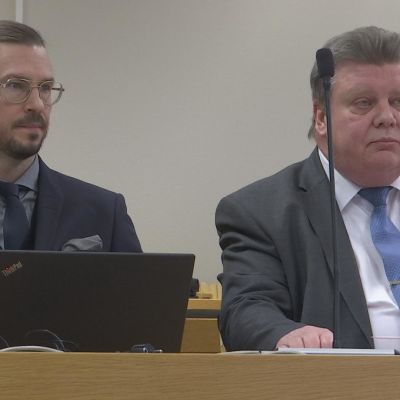 Oikeussalissa Iisakki Kiemunki ja asianajaja Olli Forsell