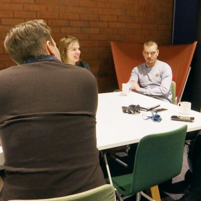 Työporukka istuu tauolla kahvipöydän ääressä