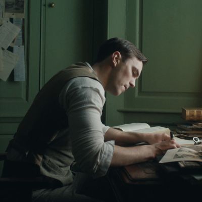 Tolkien (Nichols Hoult) sitter och skissar vid sitt skrivbord.