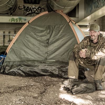 Markku Korhonen istuu teltan vieressä