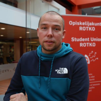 Tero Keskikallio poseeraa, opiskelijakunta Rotko esitteen edessä.