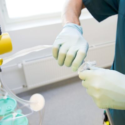 Sairaanhoitaja käsittelee hengityskonetta Meilahden tornisairaalassa.