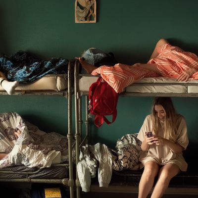 Kuvassa Eden- elokuvan hahmoja kerrossängyilla istumassa ja makaamassa erilaisissa asennoissa. Heidän takanaan on vihreä seinä.