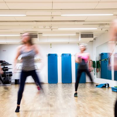 Ihmisiä jumppaamassa liikuntasalissa.