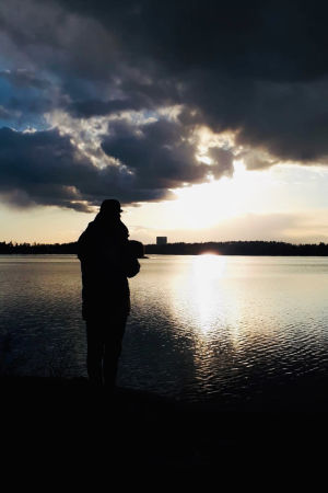 Oopperalaulaja Waltteri Torikka dramaattisessa ilta-aurinkomaisemassa.