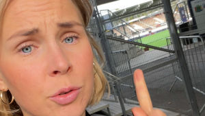 Toimittaja Sara Salmi osoittaa Töölön jalkapallostadionin nurmikenttää.