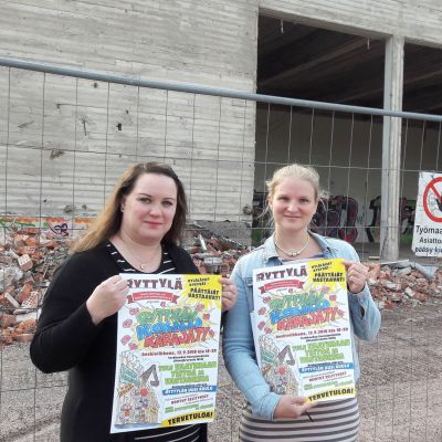 Naiset Ryttylän koulun edustalla pitelemässä julisteita