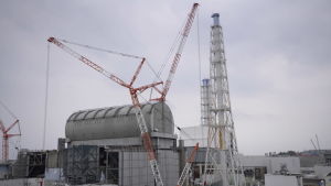 En extra överbyggnad skyddar mot strålning när reaktorn saneras. En lyftkran och stödkonstruktioner vid Fukushima.