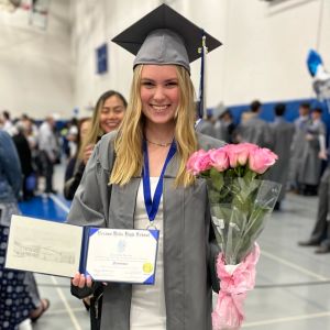 Naema Granberg står och håller i rosa rosor och sitt diplom från Vernon Hills High School i Illinois, USA.