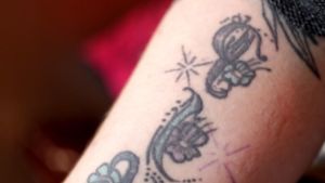 Jenni har sin dotters namn tatuerat på sin arm. En tatuering syns på en bar underarm.