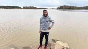 Venkat spenderar mycket tid ute i naturen. En ung man står och ler på några stenar på en strand. Bakom honom syns havet.