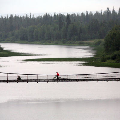 Pyöräilijä polkee sillalla Luirojoen yli