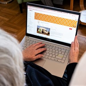 En äldre person använder en bärbar dator.