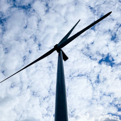 Tuulivoimalan siivet kuvattuna taivasta vasten Tyrinselän tuulivoimapuistossa