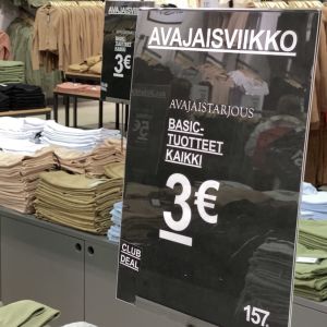 Siististi viikattujen t-paita- ja toppipinojen vieressä on tarjouskyltti. Sen mukaan kaikki basic-tuotteet maksavat avajaisviikolla kolme euroa.