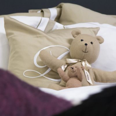 Nallet nojaavat tyynyyt pedatussa vuoteessa