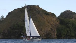 Ocean Lady närmar sig mål i Saint Lucia, Karibien. En segelbåt utanför en ö med höga klippor. Karibien Saint Lucia