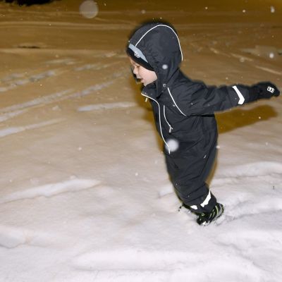 Poika leikkii lumella.