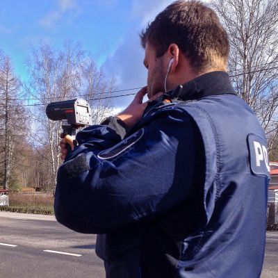 Poliisi mittaa nopeuksia.
