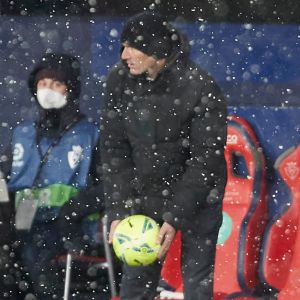 Zinedine Zidane håller i bollen framför bänken i ett snöfall.