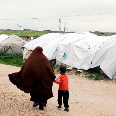 Isis-taistelijaksi epäillyn miehen vaimo käveli maaliskuussa poikansa kanssa Rojin pakolaisleirillä Koillis-Syyriassa.