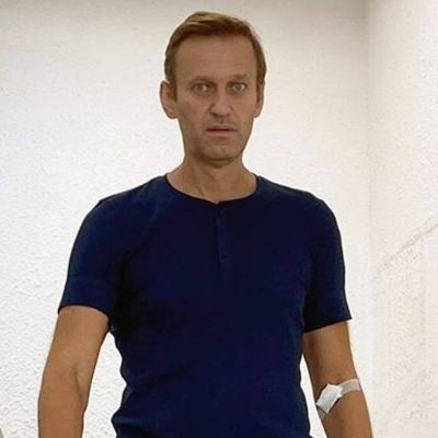 Aleksej Navalnyj går i trappan med ljusblåa plasthandskar på händerna. 
