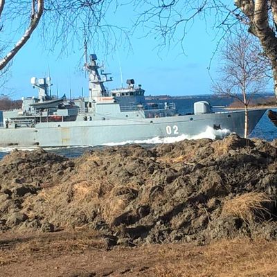 Ett militärfartyg som kör väldigt nära land på Åland.