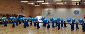 En bild på personer som gymnastiserar i Österrike. De har blåa dräkter och håller i blåa bollar