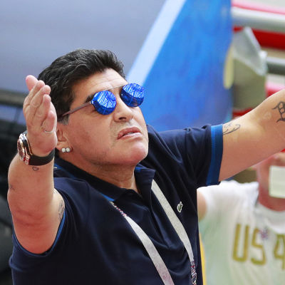 Fotbollslegenden Diego Maradona slår ut med armarna mot skyn.