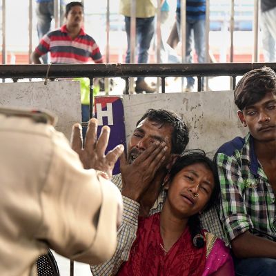 Rautatieaseman turvamies tarkkailee pidätettyjä Bangladeshiläisiä.