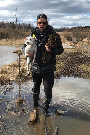 Oopperalaulaja Waltteri Torikka suomaisemassa lemmikkikoirat kainalossa.