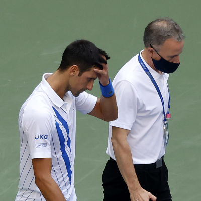 Novak Djokovic lämnar tennisplanen efter att han slagit till en boll som träffade och skadade en linjedomare.