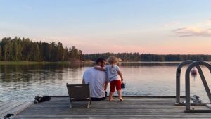 För Nora Rosendahl är sommaren tid med familjen. Man och barn på brygga ser på solnedgång.