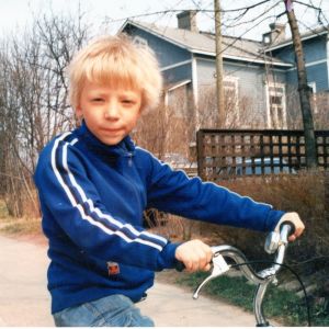 Eino Saari pikkupoikana pyörän kanssa kadulla.