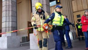 Ingångarna har spärrats av. Brandman och polis stänger och vaktar ingångarna till Helsingfors centralstation.
