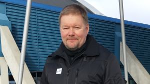 mies ulkona tumma takki päällä