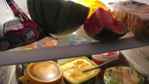 Laura berättar att den mat familjen får genom donationer äts med sparsamhet. Till exempel får varje barn en melonklyfta per dag. Melon, smör och ost i ett kylskåp.