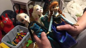 Mamman i familjen i Östra Finland berättar att "dottern höll på att svimma av lycka, då hon hittade de här dockorna i ett julklappspaket som donerats". Tre dockor i ett rum med leksaker.