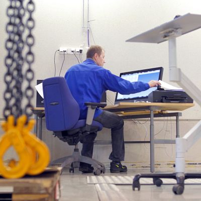 Insinööri ohjaa tietokoneen avulla mittalaitetta.