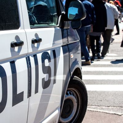 poliisiauto ja ihmisiä suojatiellä