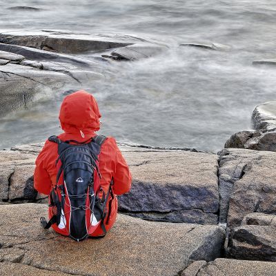 yksinäinen nainen rantakalliolla