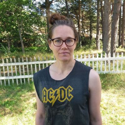 kvinna står på gräsplan vid staket med ac/dc skjorta